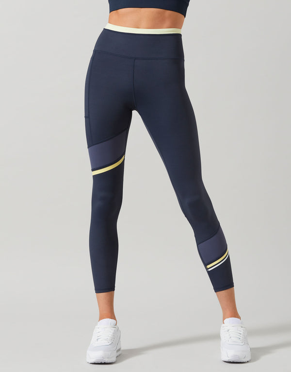Woman wearing navy blue leggings with a yellow stripe