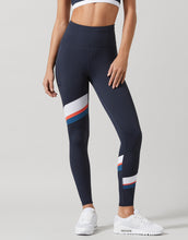 Navy leggings with colorful stripes worn by a person on a light gray background