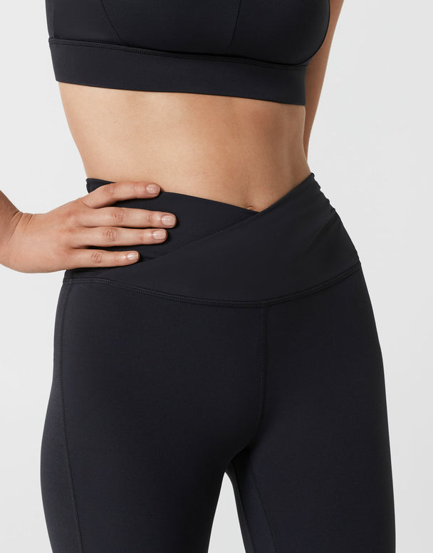 Person wearing black athletic leggings on a light gray background