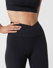 Person wearing black athletic leggings on a light gray background