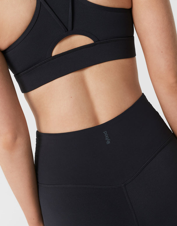 Black sports bra and leggings on a person against a white background