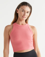 Woman wearing a pink crop top against a white background