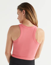 Woman wearing a pink tank top on a white background