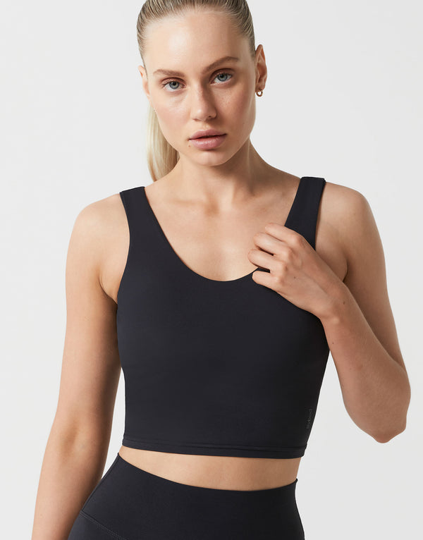 Woman wearing a black sports bra against a plain background