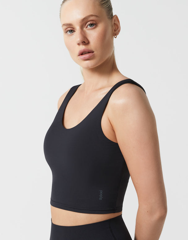 Woman wearing a black sports bra against a plain background