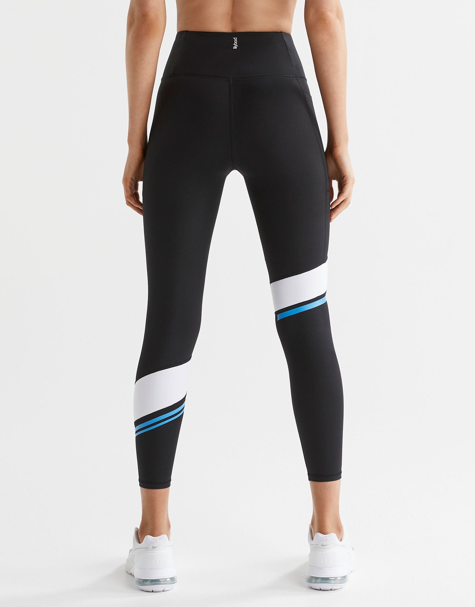 Black leggings with white and blue accents worn by a person on a white background
