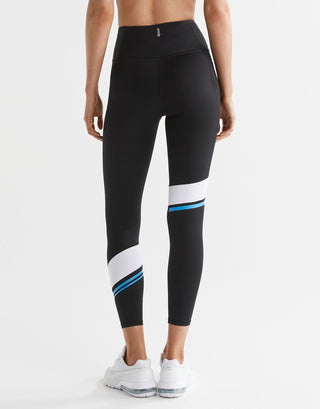 Black leggings with white and blue stripes worn by a person on a white background