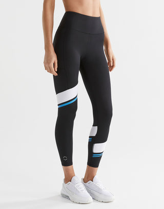 Black leggings with white and blue accents worn by a person on a white background