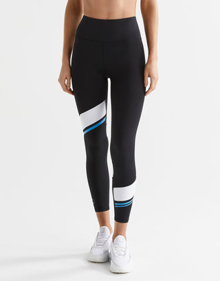 Person wearing black leggings with color block design on a white background