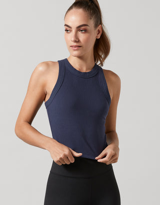 A model wearing a navy tank top and black leggings