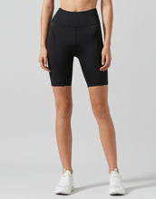 Person wearing black athletic shorts on a gray background