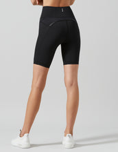 Black athletic shorts worn by a person on a gray background