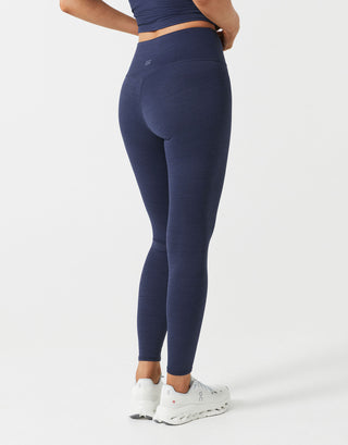 A woman wearing navy blue leggings  on a white background.