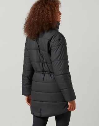 Person wearing a black puffer coat on a light gray background