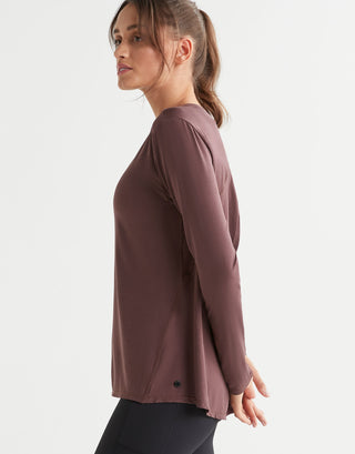 Woman wearing a brown long-sleeve top on a white background