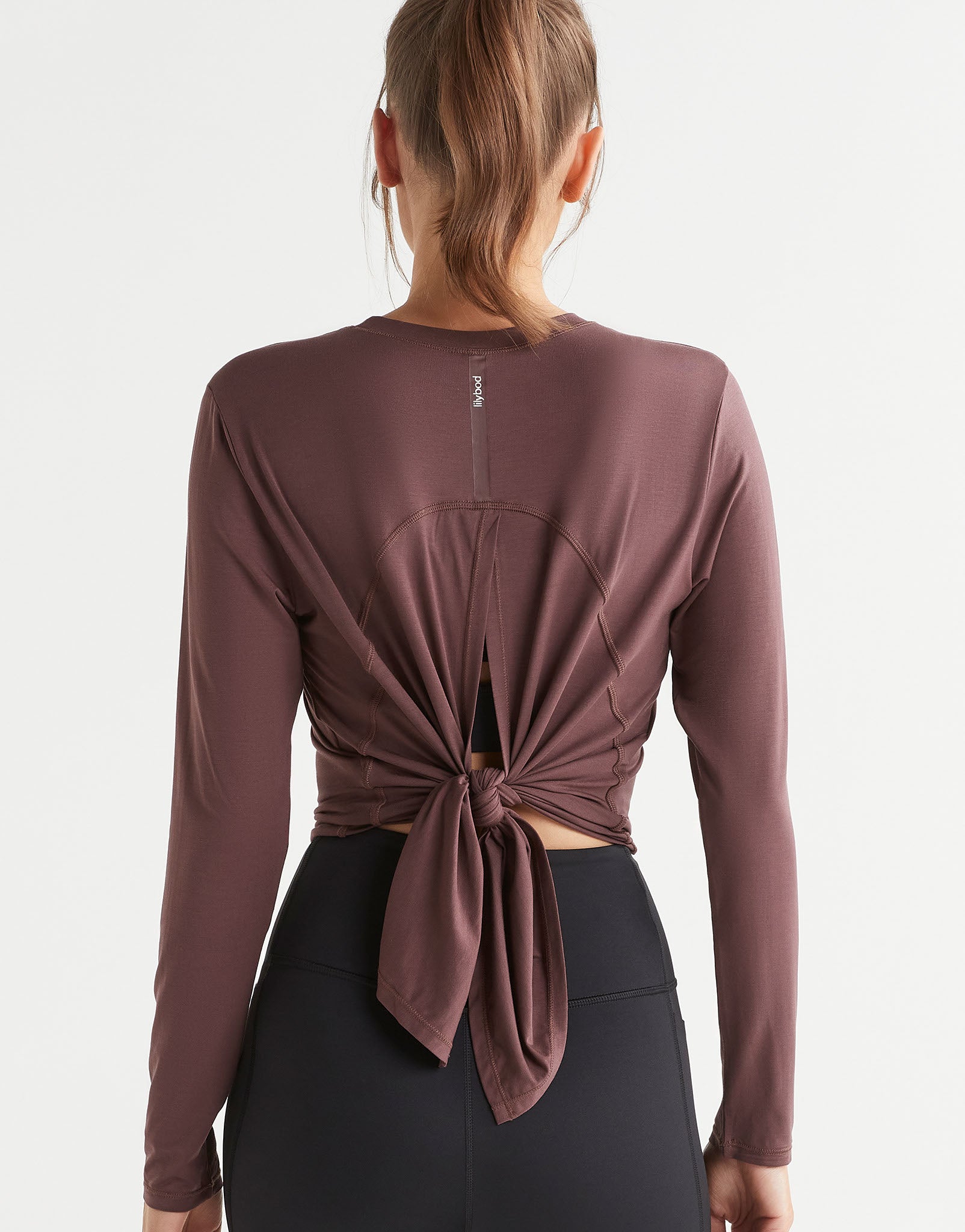 Brown long-sleeve top with knot detail on a white background