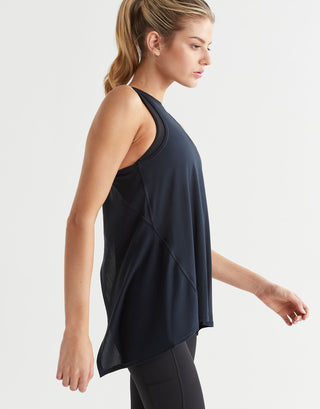 Woman wearing a dark blue sleeveless top on a light gray background