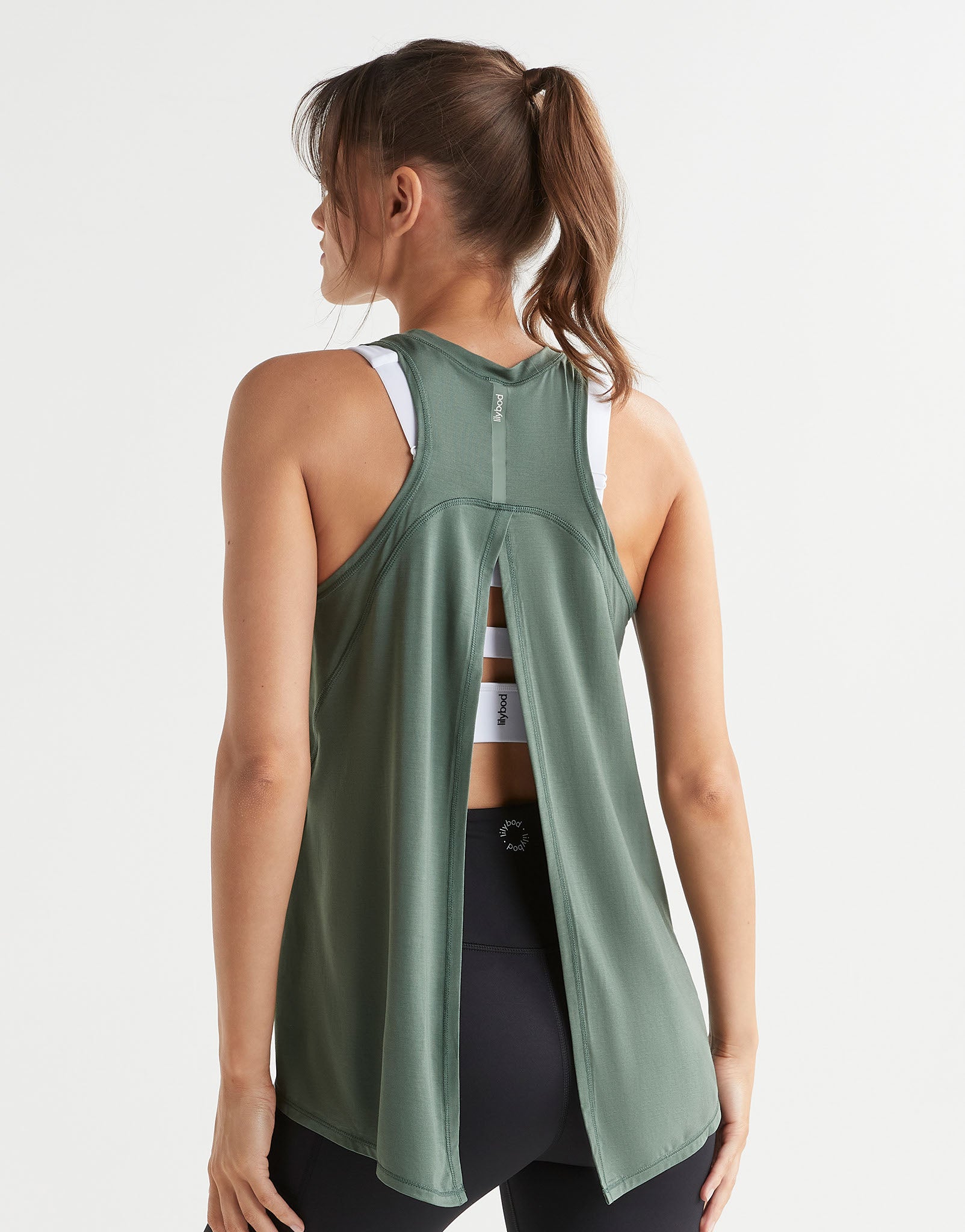 Woman wearing a green tank top with a white background