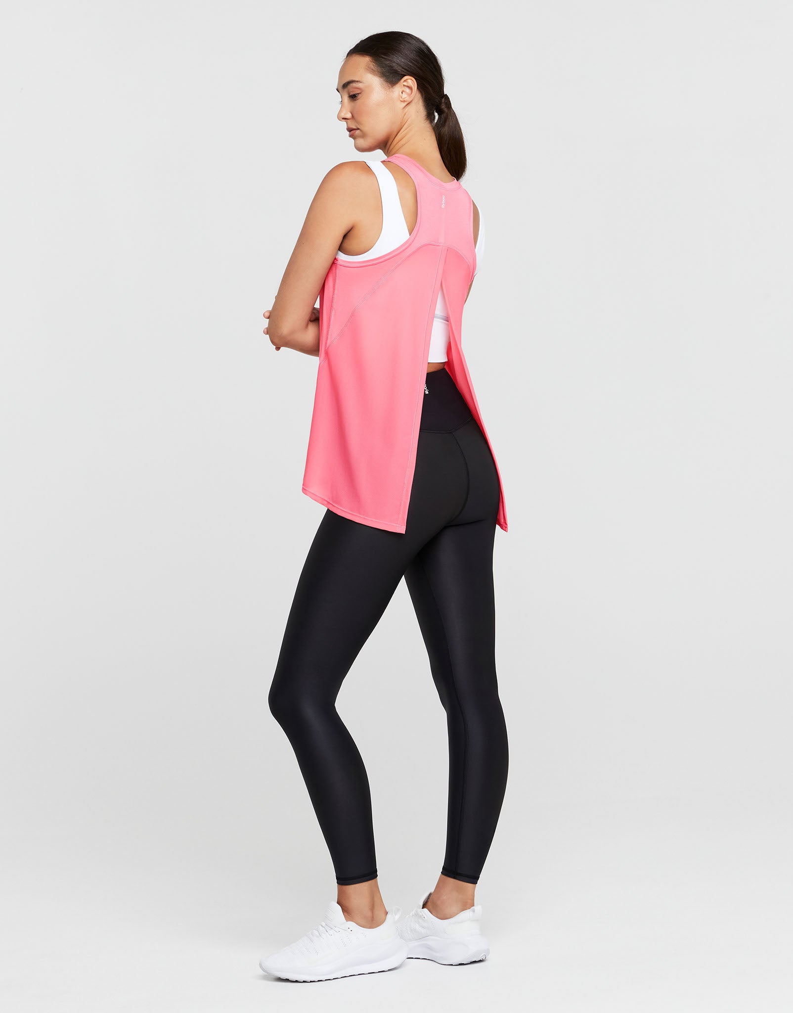Woman wearing a pink and black athletic outfit on a white background