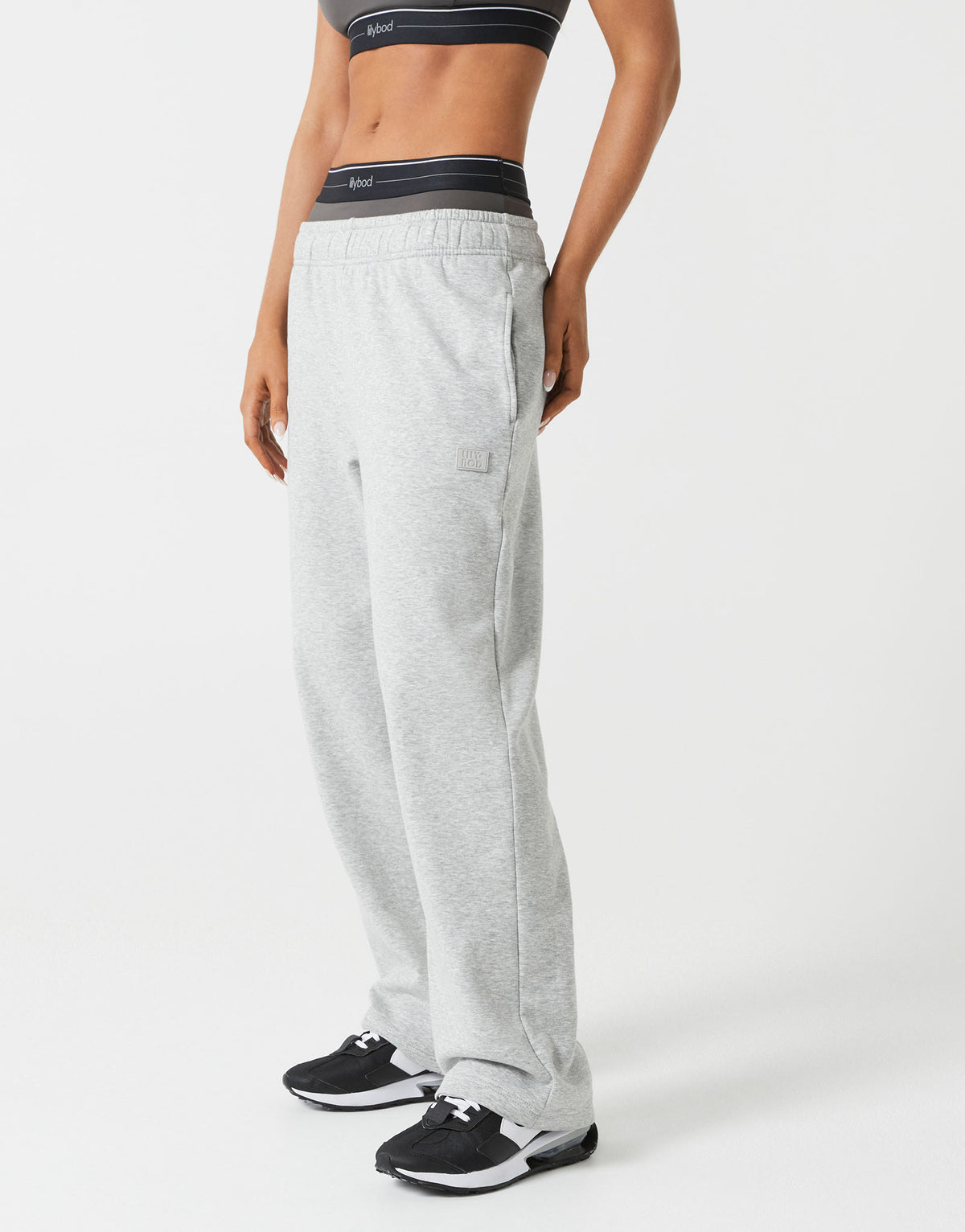 Person wearing gray sweatpants with a visible brand logo on a white background