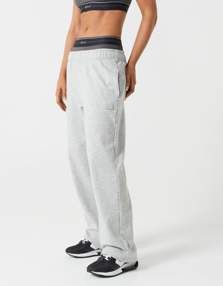 Person wearing gray sweatpants with a visible brand logo on a white background
