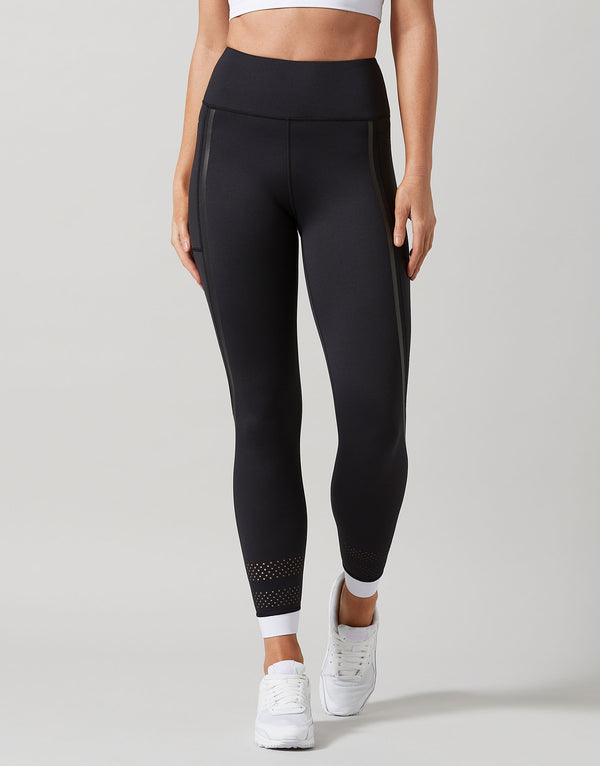 Black leggings with white accents worn by a person on a gray background