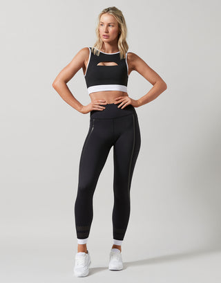 Woman wearing a black athletic outfit with a white background