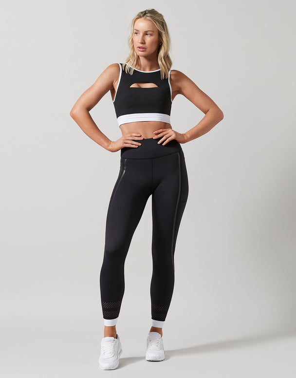 Woman wearing a black athletic outfit with a white background