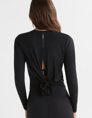 Black long-sleeve top with a knot detail on the back, worn by a person.