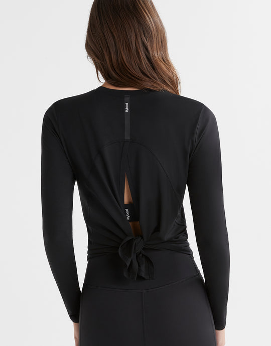 Black long-sleeve top with a knot detail on the back, worn by a person.
