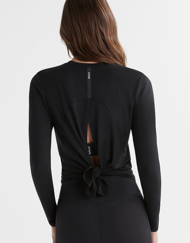 Black long-sleeve top with a knot detail on the back, worn by a person.