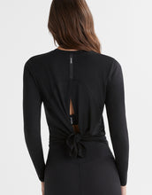 A woman wearing a black athetic top