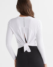 White long-sleeve top with a knot detail at the back worn by a person on a white background