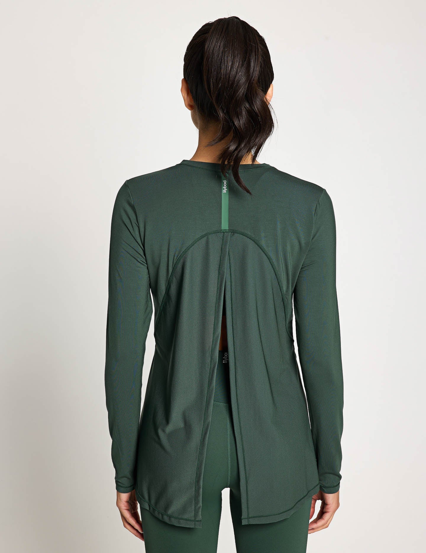 Green athletic jacket worn by a person on a plain background