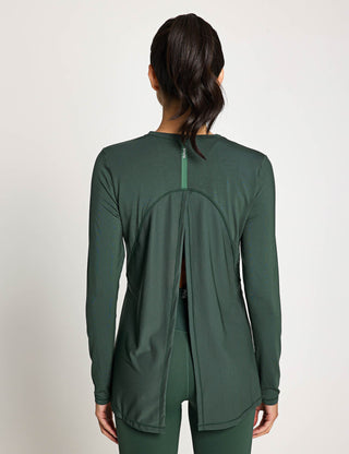 Green athletic jacket worn by a person on a plain background