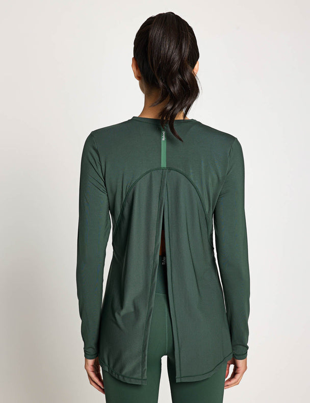 Green athletic jacket worn by a person on a plain background