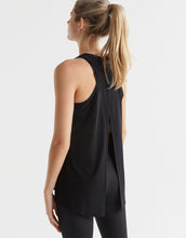 Woman wearing a black sleeveless top on a white background