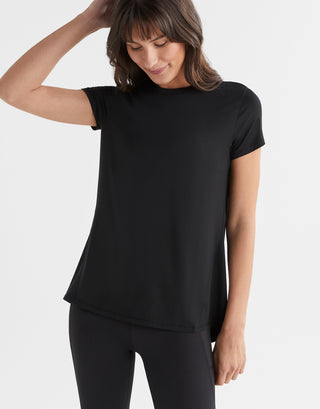 Woman wearing a black t-shirt and black leggings on a white background