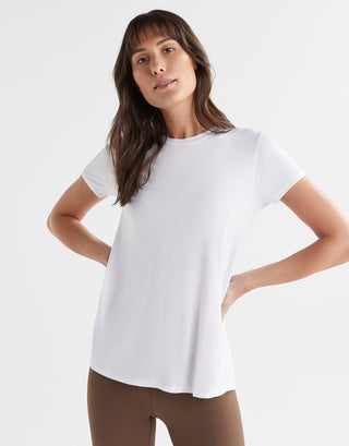 Woman wearing a white t-shirt against a plain background