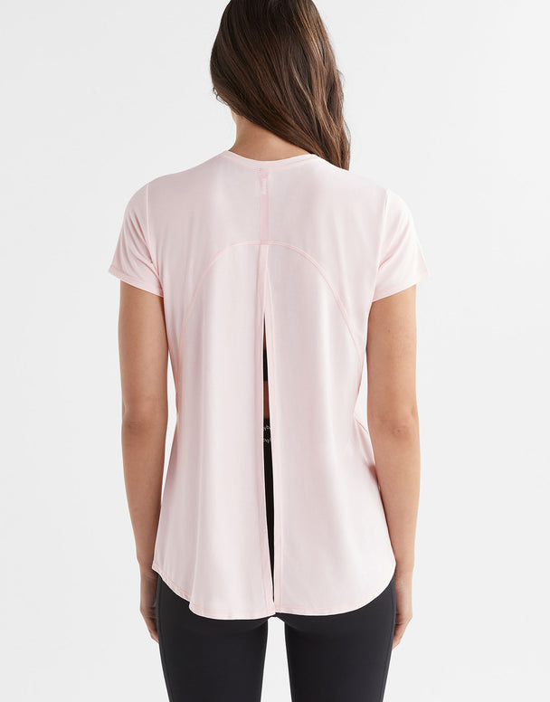 A woman wearing a pink tie up t-shirt.