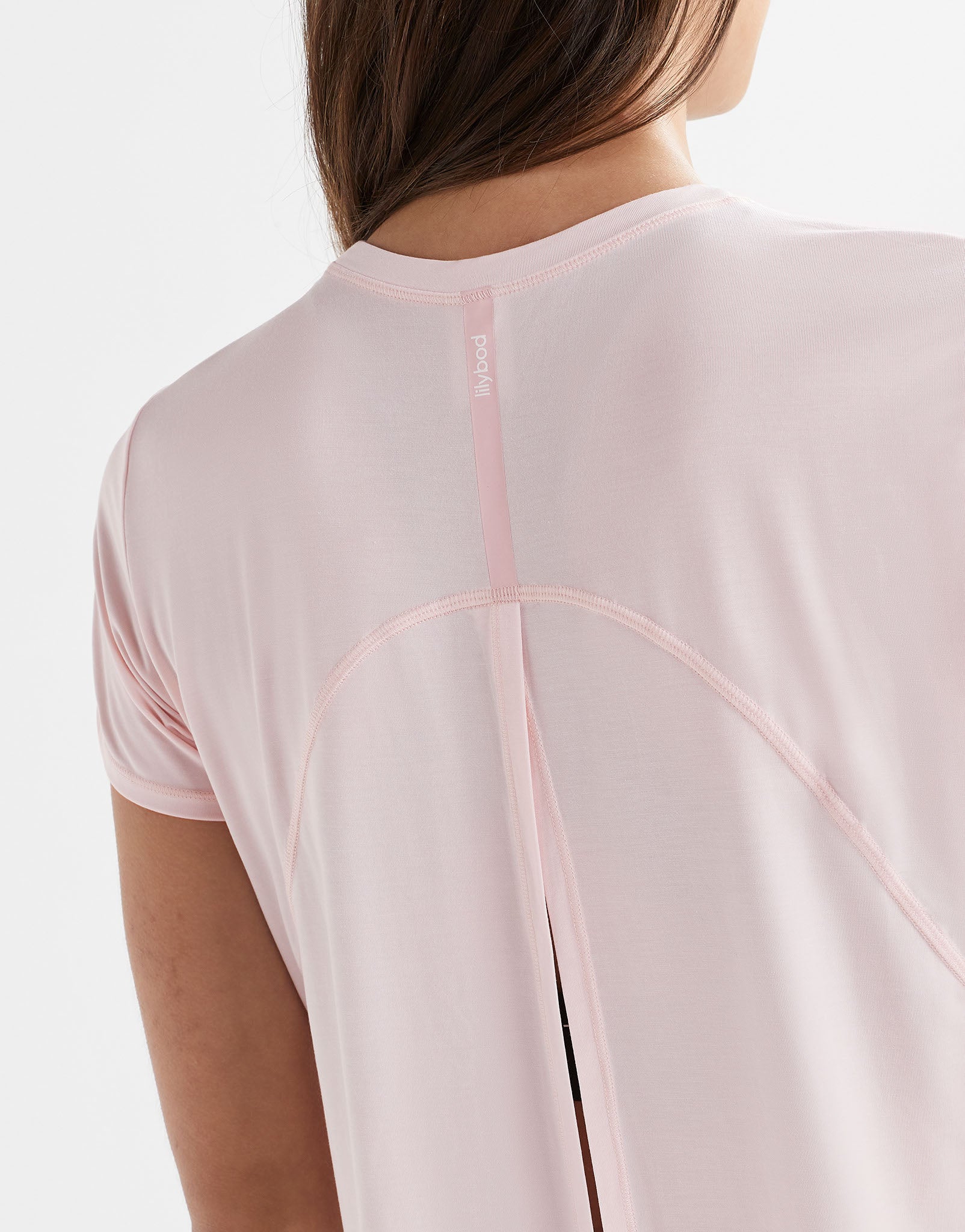 Close up of a pink top with a logo.
