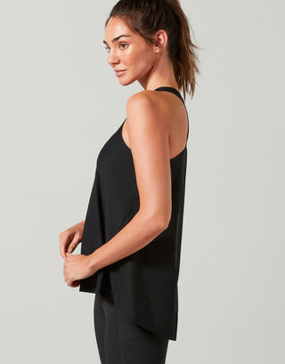 Woman wearing a black sleeveless top against a gray background