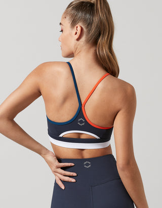 Woman wearing a sports bra and leggings with a gray background