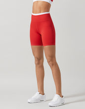 Red athletic shorts worn by a person on a plain background