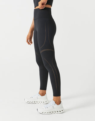 A woman wearing black leggings on a white background.