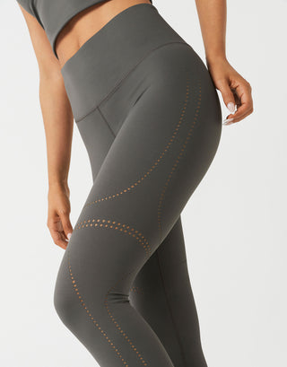 A woman wearing grey leggings on a white backround.