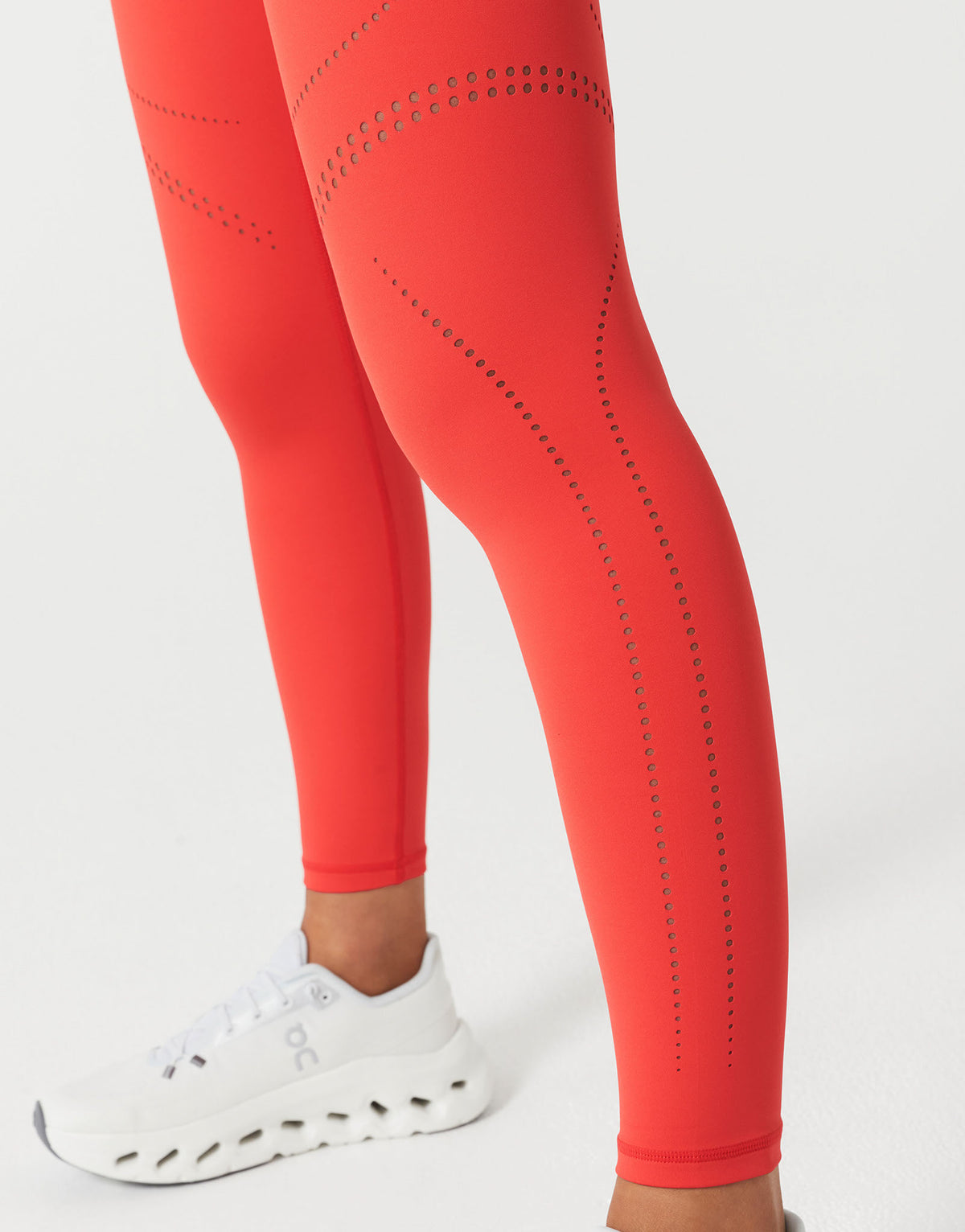  red leggings with laser cuts on a white background.