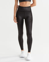 Person wearing black textured leggings on a white background