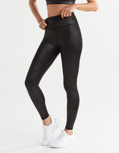 A woman wearing black shiny leggings.