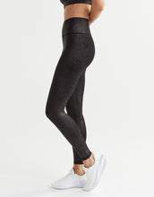 A woman wearing black animal print leggings.